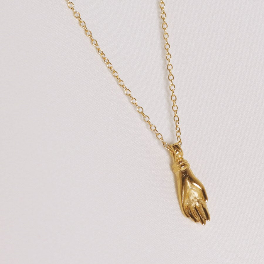 Image is the back view of gold plated hand pendant necklace, handmade by Izaskun Zabala.