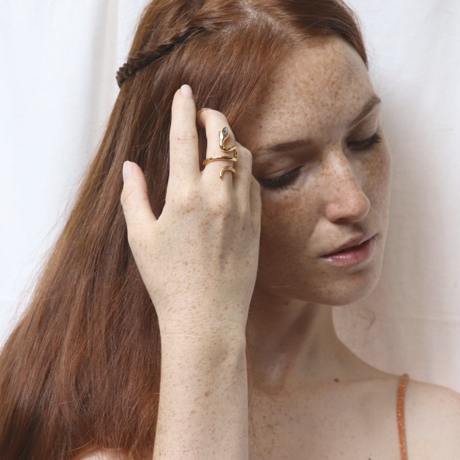 Image is a 24K gold plated snake ring with a pear shape tanzanite and two white topaz in the tail, handmade by Izaskun Zabala.