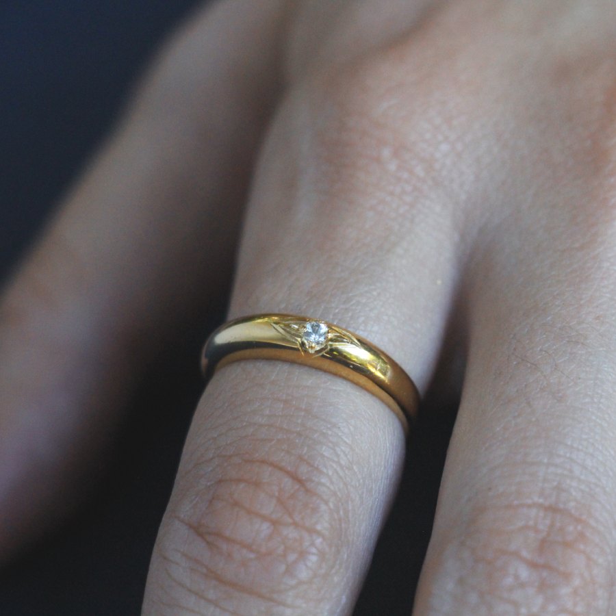 Image is a thin 24K gold plated band ring with an engraved star and white sapphire center stone, handmade by Izaskun Zabala.