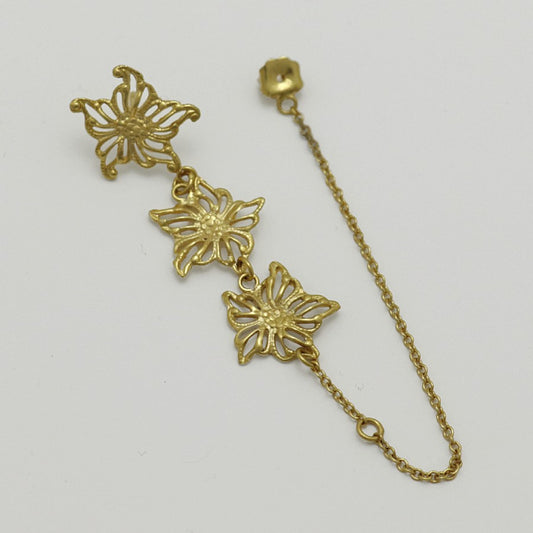 Gold-plated floral single earring, handmade by Izaskun Zabala, with a light gray background.