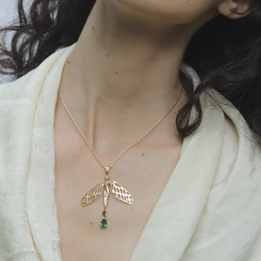 Image is a 24K gold plated dragonfly woman and tourmaline pendant with a fancy chain necklace on model, handmade by Izaskun Zabala.
