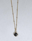 Image is a gold filled chain necklace with a cushion cut stone, handmade by Izaskun Zabala.