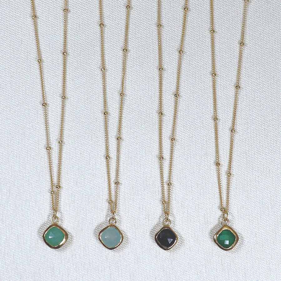 Image is a set of gold filled chain necklaces with a cushion cut stone, handmade by Izaskun Zabala.
