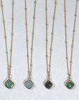 Image is a set of gold filled chain necklaces with a cushion cut stone, handmade by Izaskun Zabala.