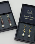 Two pairs of earrings in open jewelry boxes with 'Izaskun Zabala' branding.