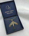 Image is a dragonfly with female body and tourmaline drop gold-plated statement necklace, displayed in the brand's packaging.