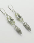 Pair of silver amphora drop earrings with green gemstones on a light gray background, handmade by Izaskun Zabala.