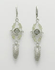Pair of silver amphora drop earrings with green gemstones on a light gray background, handmade by Izaskun Zabala.