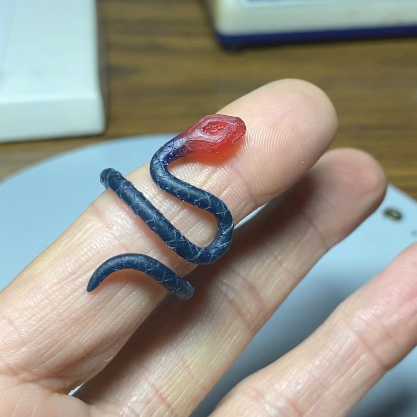 Image is a 24K gold plated snake ring with a pear shape tanzanite and two white sapphires in the tail, handmade by Izaskun Zabala.