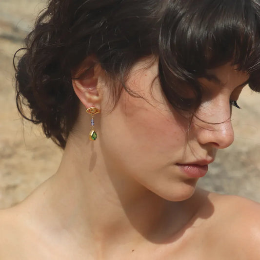 Gold-plated All-Seeing Eyes Earrings with tanzanite beads and pear shaped green crystal drops styled on a model