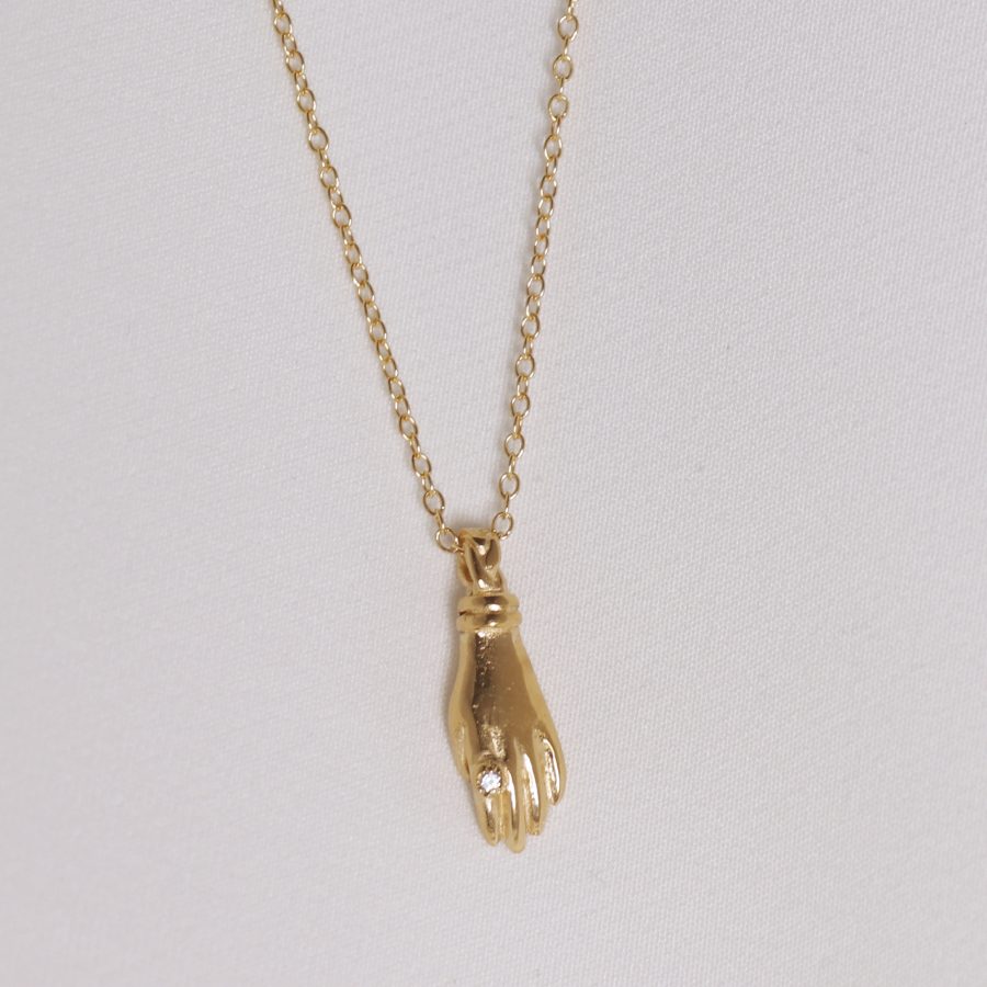 Image is a gold plated hand pendant necklace with white sapphire ring, handmade by Izaskun Zabala.