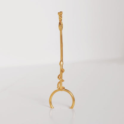Image is a 24K gold plated cigarette holder with a tsavorite eye and snake motif, handmade by Izaskun Zabala.