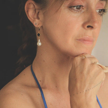Image is a pair of 24K gold plated earrings with a baroque pearl dangling from a cushion cut stone, handmade by Izaskun Zabala.
