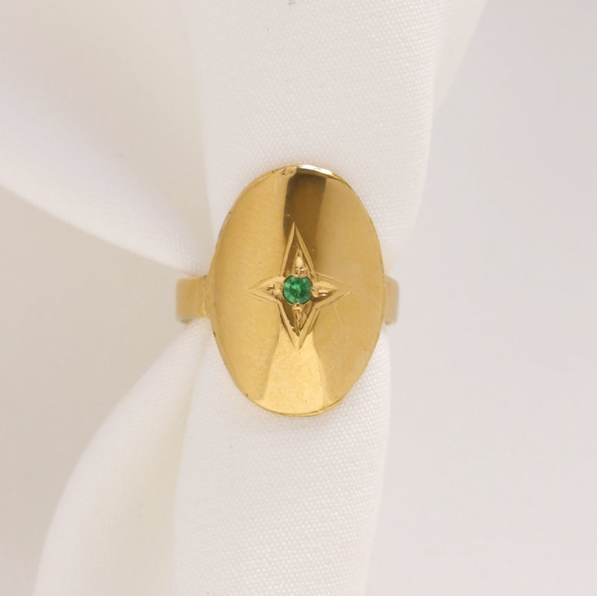 Image is a 24K gold plated adjustable oval pinky ring with an engraved star and tsavorite center stone, handmade by Izaskun Zabala.