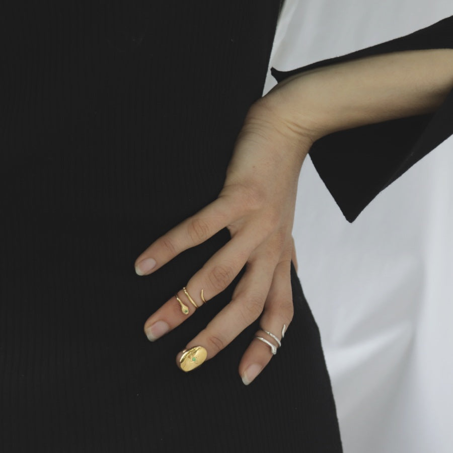 Image is golden and silver snake knuckle and nail rings on model, handmade by Izaskun Zabala.