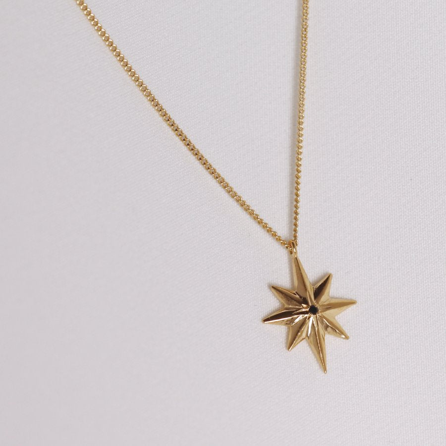 Image is a 24K gold plated star pendant with a tiny black spinel delicate necklace, handmade by Izaskun Zabala.