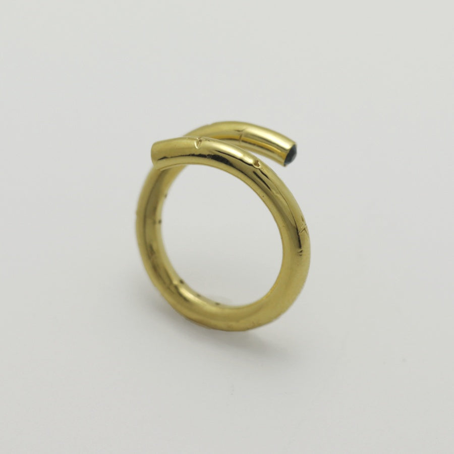 Gold plated ring with a blue sapphire stone on a light gray background, handmade by Izaskun Zabala.