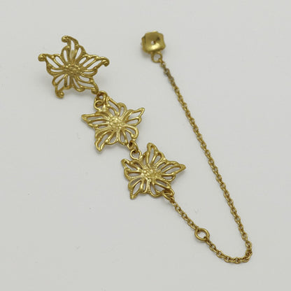 Gold-plated floral single earring, handmade by Izaskun Zabala, with a light gray background.