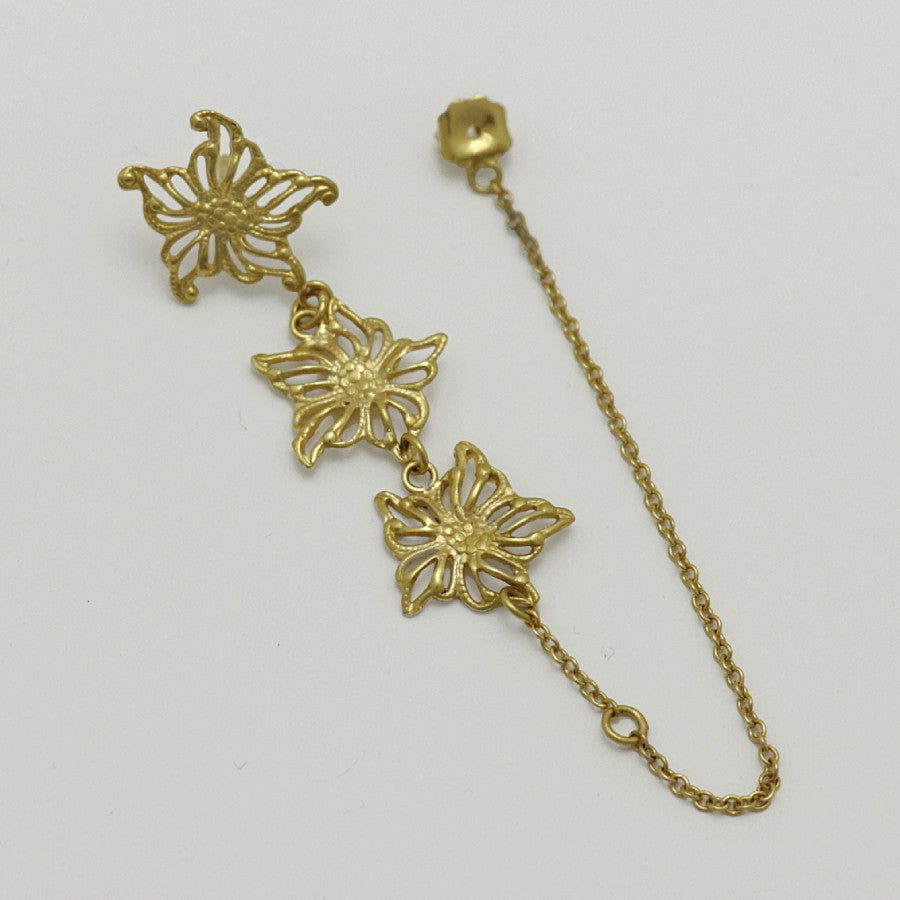 Gold-plated floral single earring, handmade by Izaskun Zabala, with a light gray background.