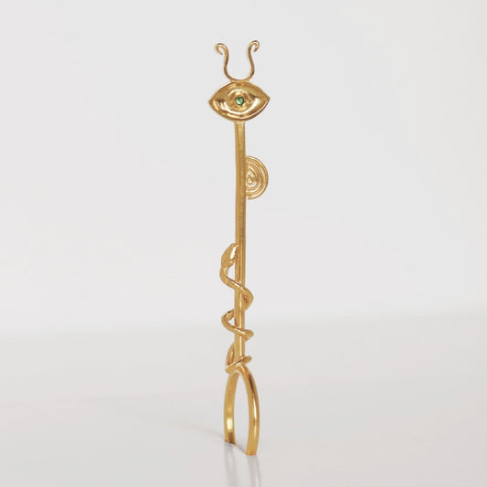 Image is a 24K gold plated cigarette holder with a tsavorite eye and snake motif, handmade by Izaskun Zabala.