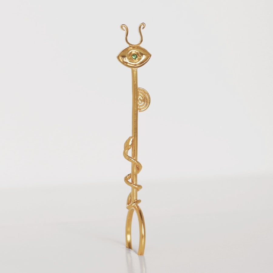 Image is a 24K gold plated cigarette holder with a tsavorite eye and snake motif, handmade by Izaskun Zabala.