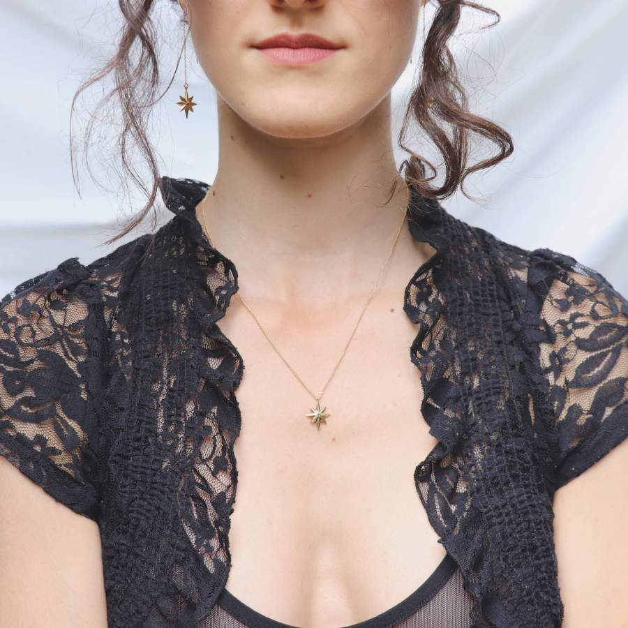 Image is a model wearing a 24K gold plated star pendant with a tiny black spinel delicate necklace, handmade by Izaskun Zabala.