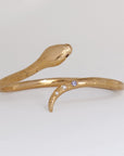 Image is a 24K gold plated snake cuff with garnet eyes, tanzanite and white topaz stones, handmade by Izaskun Zabala.