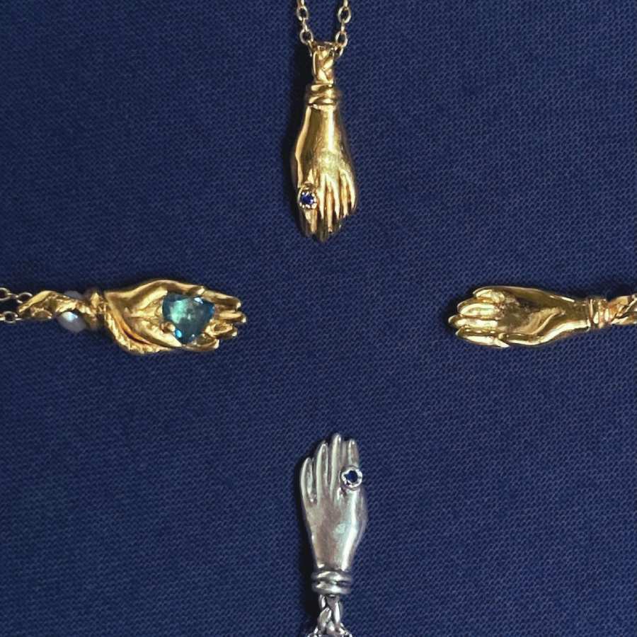 Image is four gold plated and silver hand pendant necklaces with miniature stone ring, handmade by Izaskun Zabala.