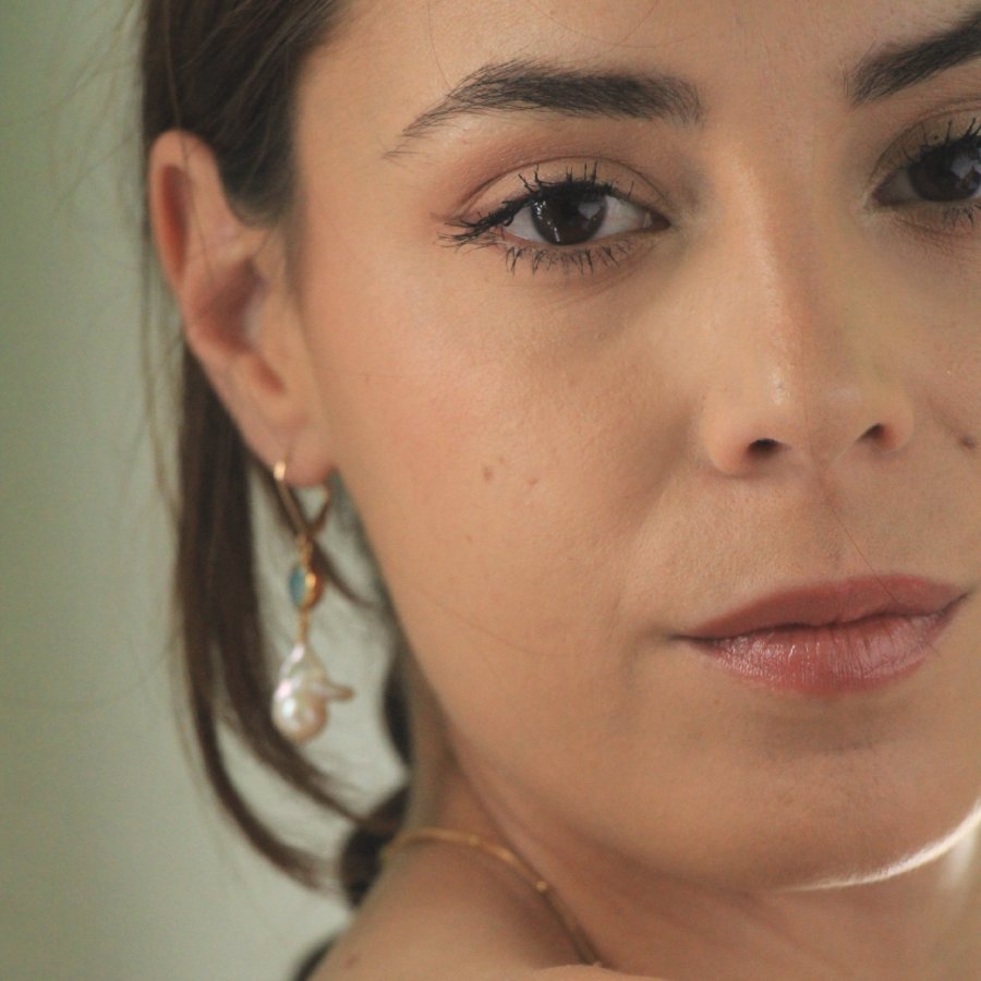 Image is a pair of 24K gold plated earrings with a baroque pearl dangling from a cushion cut stone, handmade by Izaskun Zabala.