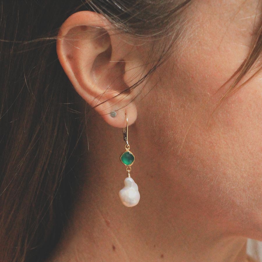 Image is a pair of 24K gold plated earrings with a baroque pearl dangling from a cushion cut stone, handmade by Izaskun Zabala.