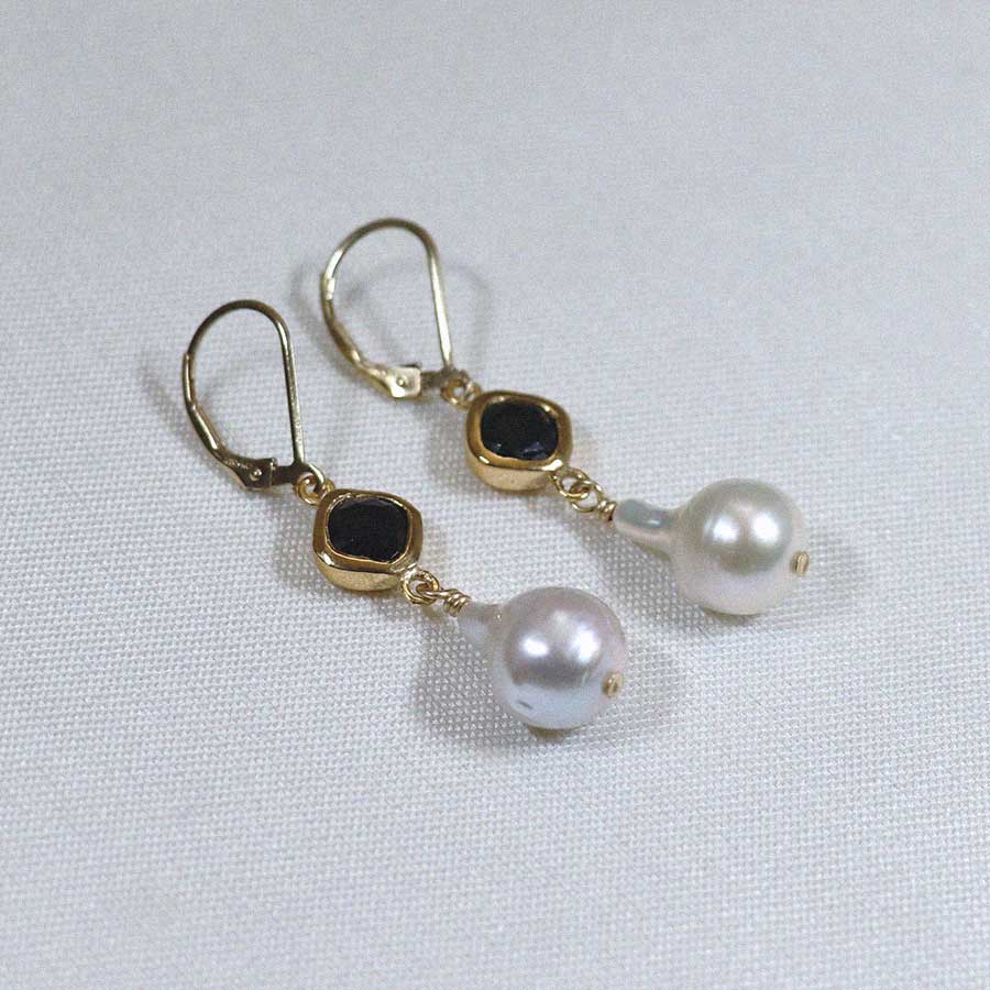 Image is a pair of 24K gold plated earrings with a baroque pearl dangling from a cushion cut stone, handmade by Izaskun Zabala.