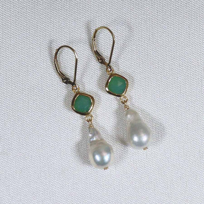 Image is a pair of 24K gold plated earrings with a baroque pearl dangling from a cushion cut stone, handmade by Izaskun Zabala.