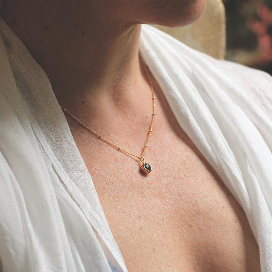 Image is a gold filled chain necklace with a cushion cut stone, handmade by Izaskun Zabala.
