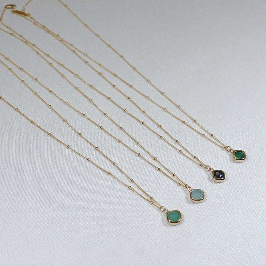 Image is a set of gold filled chain necklaces with a cushion cut stone, handmade by Izaskun Zabala.