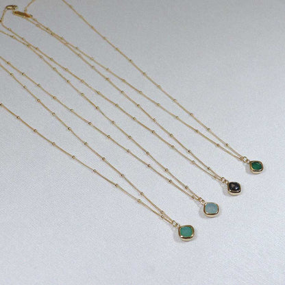 Image is a set of gold filled chain necklaces with a cushion cut stone, handmade by Izaskun Zabala.