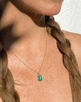 Image is a necklace with an oval malachite cabochon set in a brass pendant with a gold filled chain handmade by Izaskun Zabala.