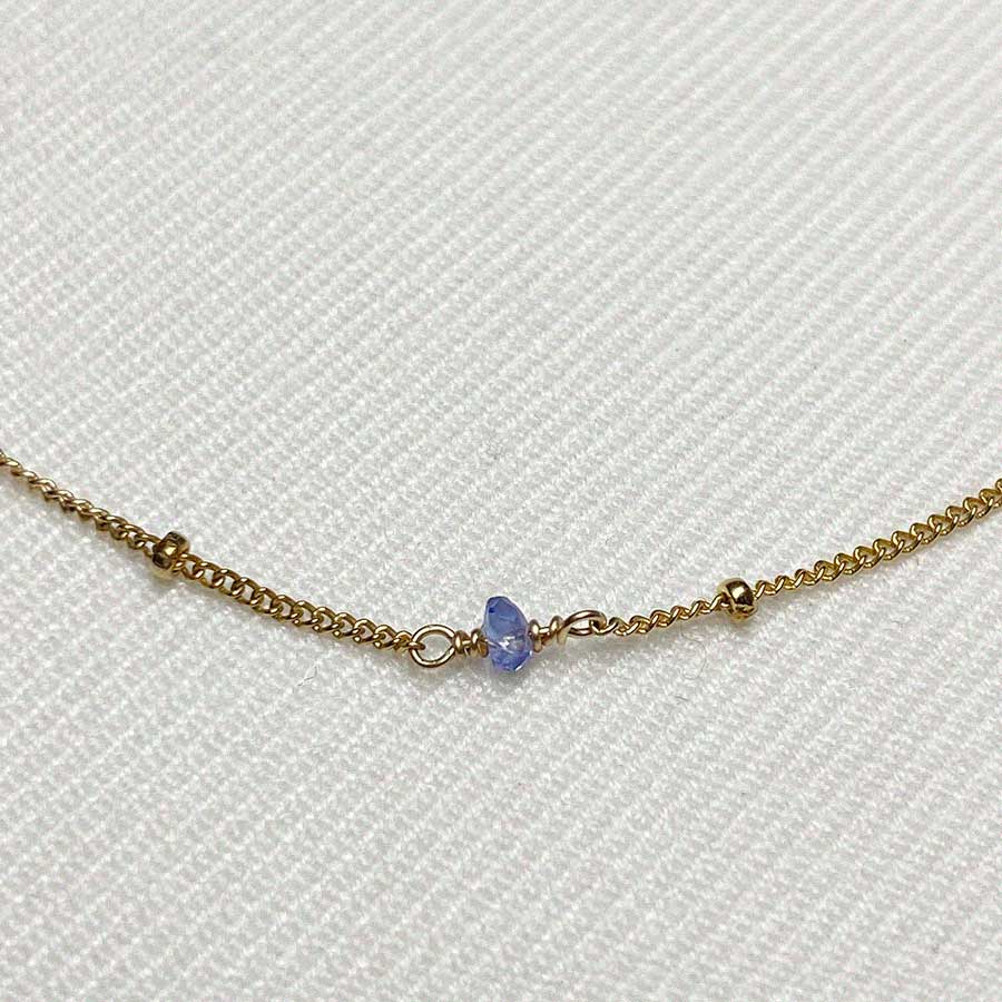 Image is a delicate gold filled chain necklace with tanzanite stone beads, handmade by Izaskun Zabala.