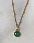 Image is a delicate gold filled chain necklace with a cushion cut green onyx stone, handmade by Izaskun Zabala.