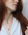 Image is a delicate gold filled chain necklace with a cushion cut green onyx stone, handmade by Izaskun Zabala.