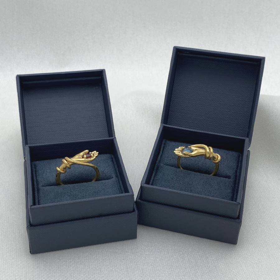 Image is a set of gold-plated palmistry rings with gemstone displayed in the brand's packaging.