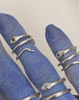 Image is a pair of silver snake pinky rings with gemstone on a hand, handmade by Izaskun Zabala.