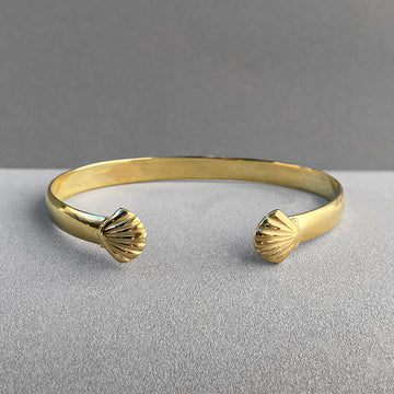 Image is a gold plated cuff with a shell motif on each end, handmade by Izaskun Zabala.