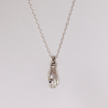 Image is a silver hand pendant necklace with blue topaz ring, handmade by Izaskun Zabala.