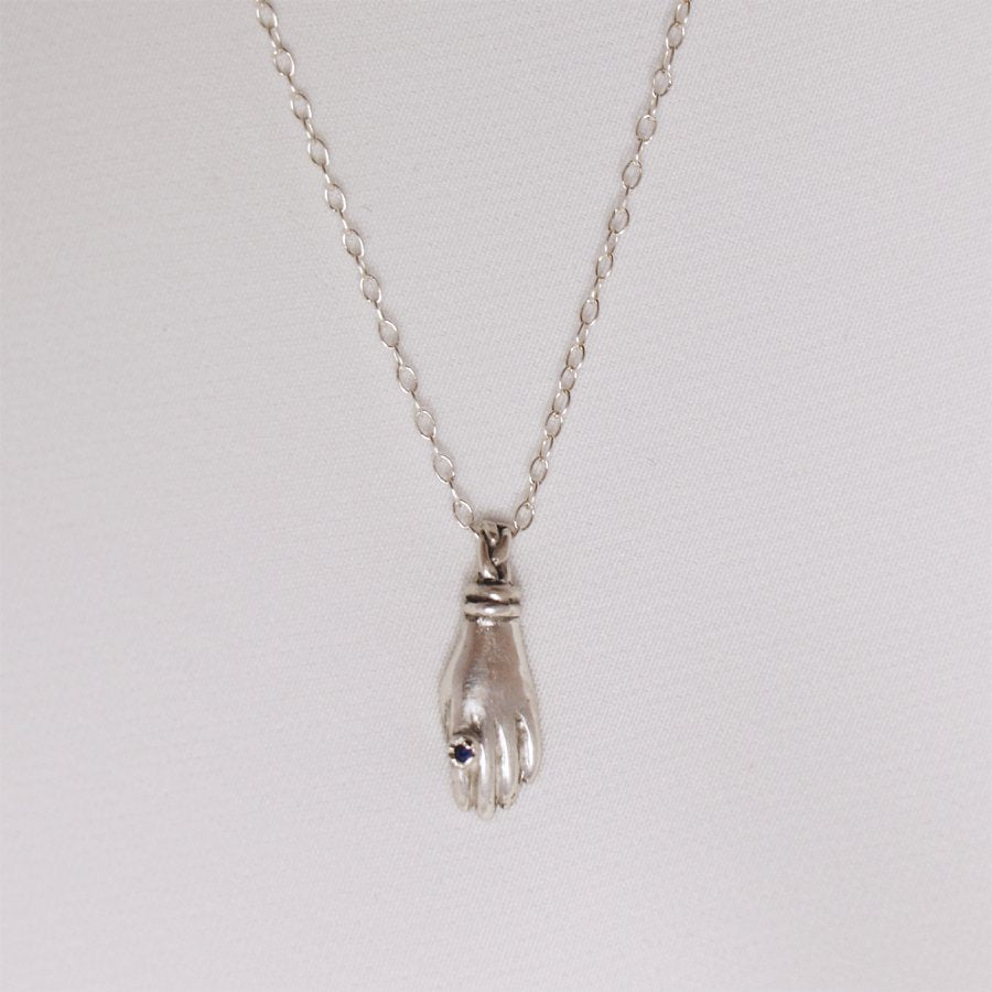 Image is a silver hand pendant necklace with blue topaz ring, handmade by Izaskun Zabala.