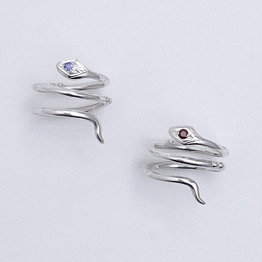 Image is a pair of silver snake pinky rings with gemstone, handmade by Izaskun Zabala.