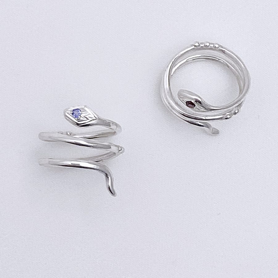 Image is a pair of silver snake knuckle rings with gemstone, handmade by Izaskun Zabala.