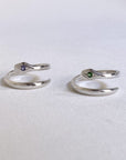 Image is a pair of silver minimalist snake rings with gemstone, handmade by Izaskun Zabala.