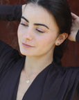 Woman wearing gold-plated yin yang stud earrings and necklace, made by artisan Izaskun Zabala.
