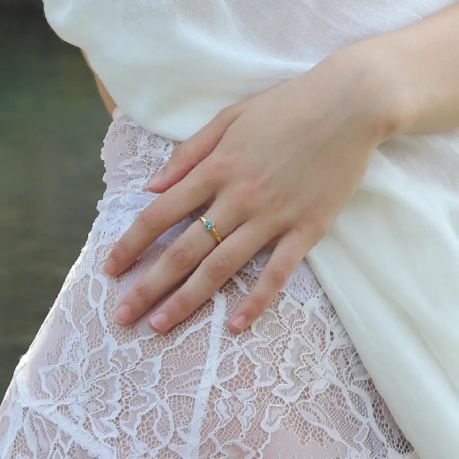 Gold-plated Adhara Ring with center topaz worn on a model