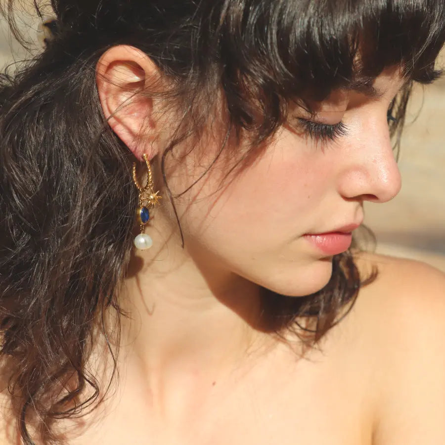 Gold-plated Alba drop Hoops with sun charm, lapis lazuli and pearl, worn on a model